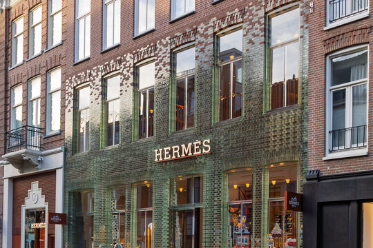 Facade of Herm&egrave;s store featuring the Crystal Houses design with glass bricks merging into terracotta bricks on P.C. Hooftstraat. Amsterdam Netherlands, 28 december 2025