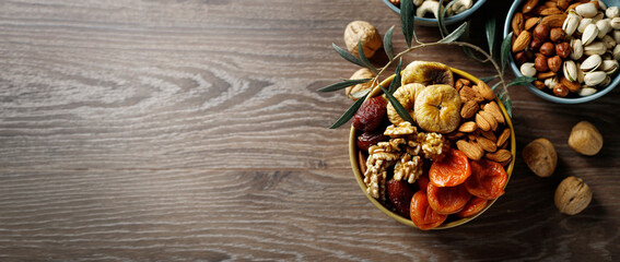Mixed nuts and dried fruit on a wooden background. Symbols of Jewish holiday Tu Bishvat.
