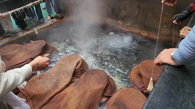 Gurudwara sahib manikaran with beautiful view of parvati river and walking people on bridge. Statue of Lord Shiva striking the ground with his trident over hot water gushing out of the ground.