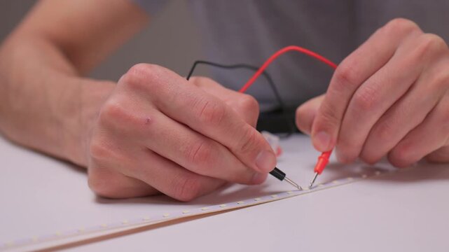 Closeup of soldering process, Electronics hobbyist connecting copper pads using hot iron tool, Detailed view of person soldering wires onto LED strip with precision guidance