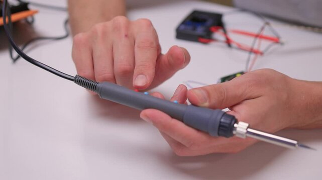 Precision soldering procedure, Hands meticulously align soldering tool precisely, Technician in closeup carefully adjusting soldering tip with safety and measurement focus