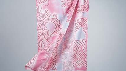 Adire fabric in soft pink tones with delicate patterns showcasing traditional textile design
