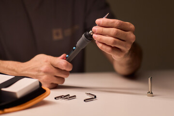 Precision soldering procedure, Hands meticulously align soldering tool precisely, Technician in closeup carefully adjusting soldering tip with safety and measurement focus