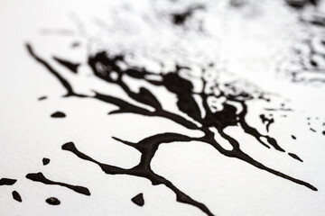 Extreme close up of black acrylic paint texture on paper. Selective focus.