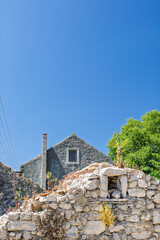 Obraz premium Old Stone House Under Clear Blue Sky With Stone Wall And Ruins In Rural Setting, Orebic, Croatia