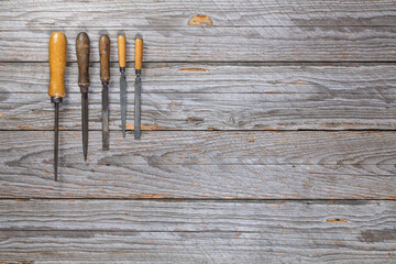 Five Worn Metal Files with Wooden Handles on Weathered Workbench, Top View
