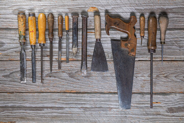 Vintage Hand Tools Collection on Weathered Wooden Workbench, Top View
