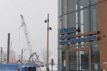 Naklejka premium construction site and sign outside East Bayfront Community Recreation Centre located at 261 Queens Quay E, during a snow storm on 2026-01-15 in Toronto