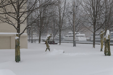 Obraz premium wide view of sculptures by Irish artist Rowan Gillespie part of The Arrival, set beside the old Canada Malting silos on Eireann Quay, during winter storm on 2026-01-15 in Toronto