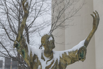 Obraz premium front of The Jubilant Man created by Irish artist Rowan Gillespie part of The Arrival, set beside the old Canada Malting silos on Eireann Quay, Toronto, during winter storm on 2026-01-15