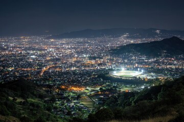 Fototapeta premium Vast Urban Nightscape - Sparkling City Lights and Bright Stadium from High Vantage Point.