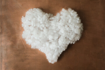 Soft polyester fiberfill heart shape on a copper plate. Fluffy heart. Valentine&rsquo;s Day Love concept.