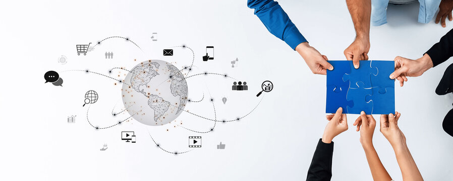 Diverse hands come together to solve a puzzle, symbolizing teamwork and global connectivity in a modern workspace filled with digital elements and visual communication. Trope - Powered by Adobe