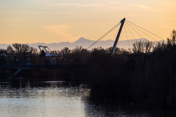 Robert Poujade Bridge crossing the Garonne River with snow-covered Pyrenees mountains in the background at sunset in Toulouse