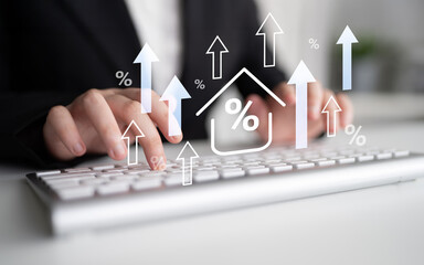 A close-up view of a businessman typing on a keyboard, with an overlay of upward arrows and percentage symbols representing financial growth and success in a modern office. Gantry