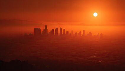 Sun rises over foggy cityscape, silhouetting tall buildings