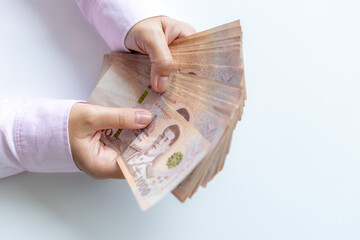Money, Cash, Wealth, Hands holding a large amount of Thai baht banknotes, symbolizing cash, wealth, and financial success, close-up