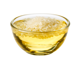 Rice bran oil with uncooked grains in a clear glass bowl, a healthy cooking ingredient for culinary use, showcasing the raw, natural food components in a studio shot