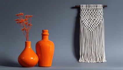 Gray wall with orange vases and macrame wall hanging
