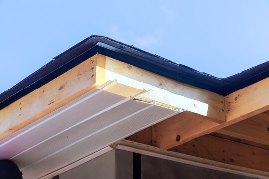 Roof edge construction with wooden beams vinyl siding in home renovation project