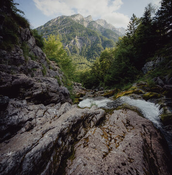 Blick auf die junge Soča, wie sie kurz unterhalb der Quelle am Fu&szlig;e des Travnik &uuml;ber moosbedeckte Felsen pl&auml;tschert, Slowenien, Julische Alpen