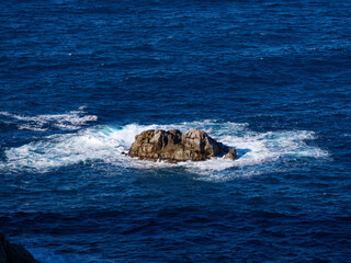 Wild rocky coastline of Capo di Muro in Corsica with crashing waves on Mediterranean Sea