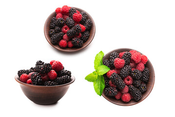 Raspberry, blackberry and mint leaf in ceramic brown bowl isolated on white © Nikolay