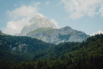 Fototapeta premium Blick auf den teilweise in Wolken eingehüllten Mangart, Julische Alpen, Slowenien
