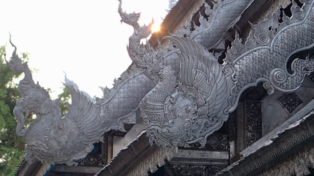 Horizontal Video - silver naga sculptures on the roof of a thai temple