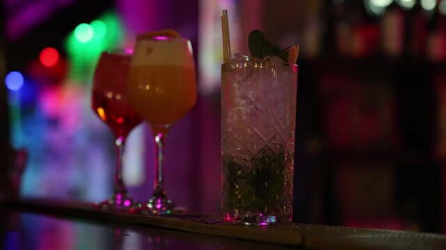 Three vibrant cocktails on a bar counter in colorful ambient lighting, creating a stylish, festive atmosphere perfect for nightlife, mixology, and modern bar promotions.