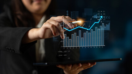 A business professional engages with a virtual display that showcases important analytical data, reflecting growth trends in a contemporary office setting. Scalp