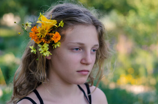 portrait of teenage girl with orange and yellow flowers in hair