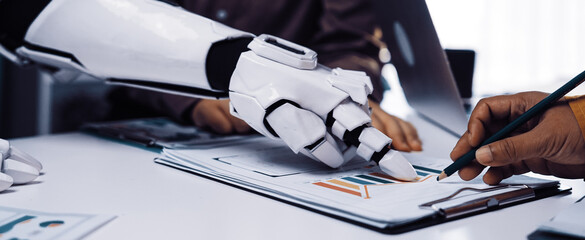 A dynamic interaction between a human and a robotic arm in a sleek office setting, symbolizing the future of collaboration and technological innovation in workspaces.Noogenesis