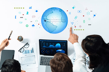 This image illustrates a collaborative business environment, showcasing data analysis with global graphics, charts, and technology, ideal for corporate presentations. Trope