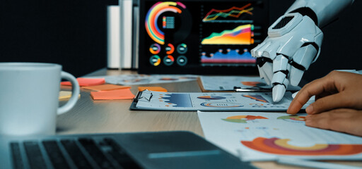 A sophisticated workspace featuring a robotic hand analyzing charts and business data, reflecting...