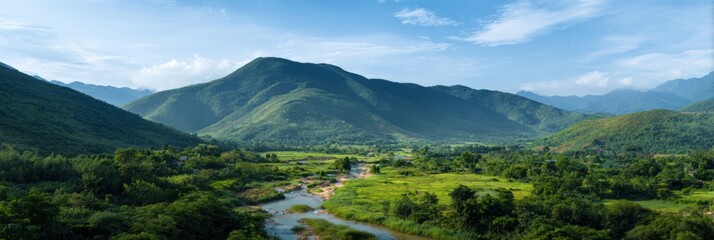 Fototapeta premium Verdant mountain valley with river and blue sky in tranquil landscape