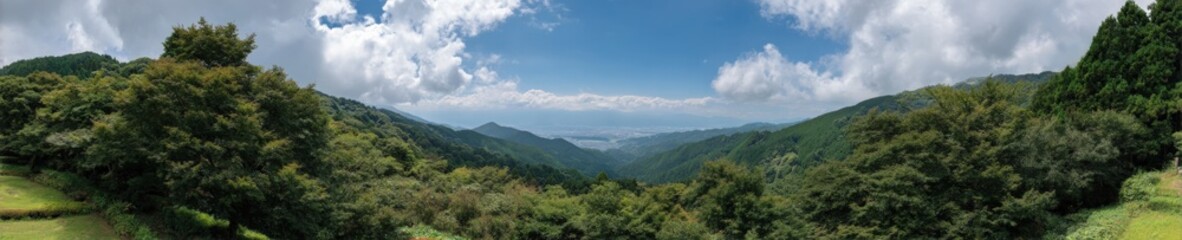 Naklejka premium Majestic mountain valley panorama with lush green forests and blue sky