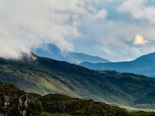 Rolling hills stretch into the distance, partially veiled by low clouds and morning haze.