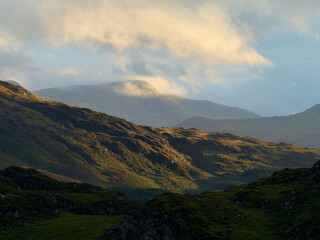 A scenic mountain landscape bathed in golden sunlight.