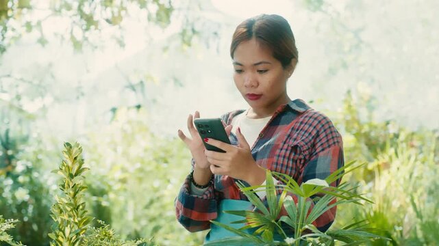 Woman Using Smart phone in Lush Garden