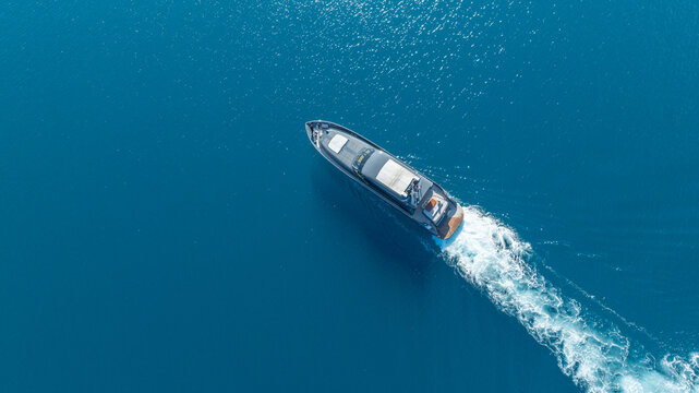 Seafaring Vessel: Aerial perspective of a sleek vessel navigating across a vast, tranquil expanse of ocean, leaving a wake.