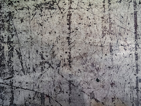 Heavily scratched and worn gray metal surface showing industrial wear patterns and abstract texture