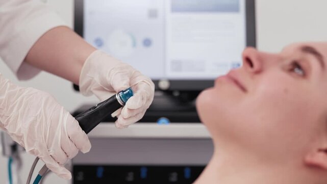 Young woman receives HydraFacial in a beauty clinic, showcasing skin cleansing and improved skin texture. Concept skin cleansing, skin texture, professional skincare