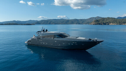 Luxurious yacht on the water: An elegant yacht glides across tranquil water under a clear sky. A symbol of luxury and adventure on open sea