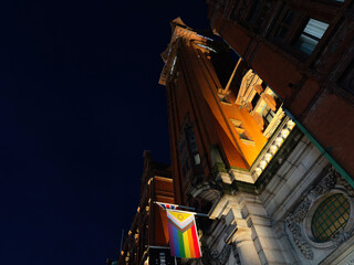 Naklejka premium Night view of a historic Manchester building with rainbow flag illuminated facade