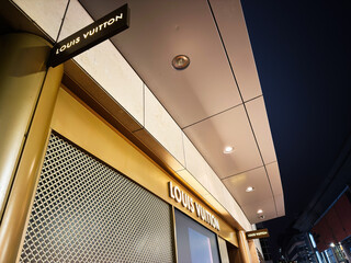 Naklejka premium Louis Vuitton store exterior at night in Manchester showcasing luxury storefront and signage