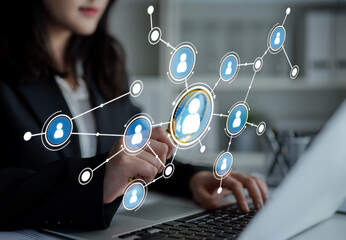 A businesswoman interacts with a digital network visualization on her laptop, showcasing user connections in a modern office. This image reflects innovation and technology in the workplace. Crux