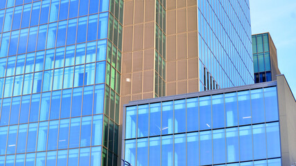 A modern tall building made of steel and glass, housing offices and financial institutions. Glass wall on the facade of the building.