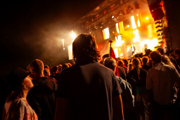 Audience watching live concert performance with dramatic stage lighting and atmosphere. Music festival, entertainment event, and nightlife photography for concert and event marketing content.