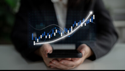 A business professional examines financial growth trends using a smartphone, with a digital graph illustrating an upward trajectory in a modern office setting. Impute